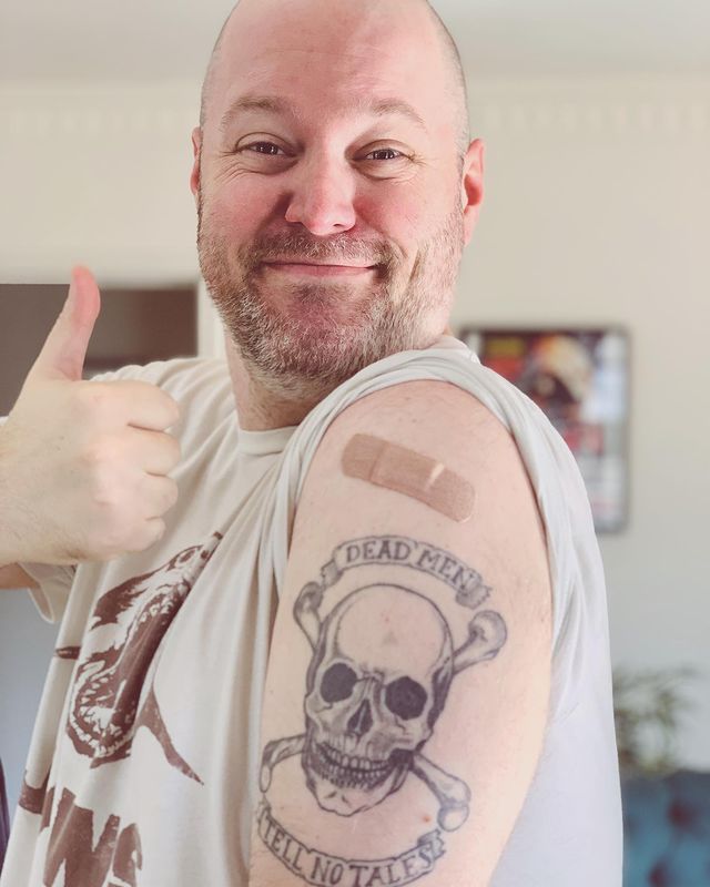 Lee Boxleitner giving a thumbs up showing his Skull Leaves tattoo.